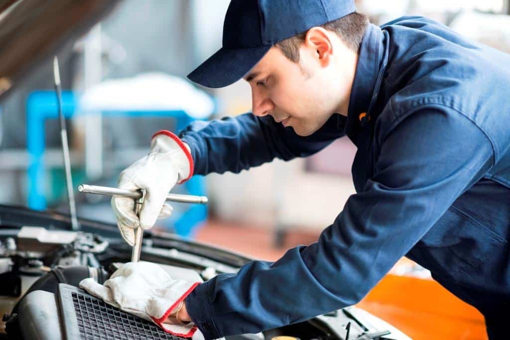 Auto mechanic working on a car in his garage