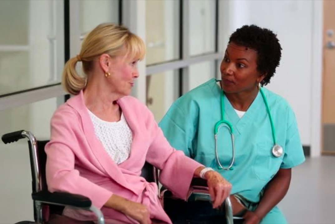A nurse caring for a lady in a hospital setting